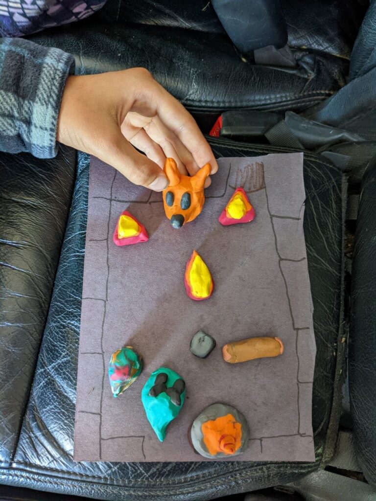 Clay models of Fang the Fox, flames, gems and a goo monster on a hand-drawn level