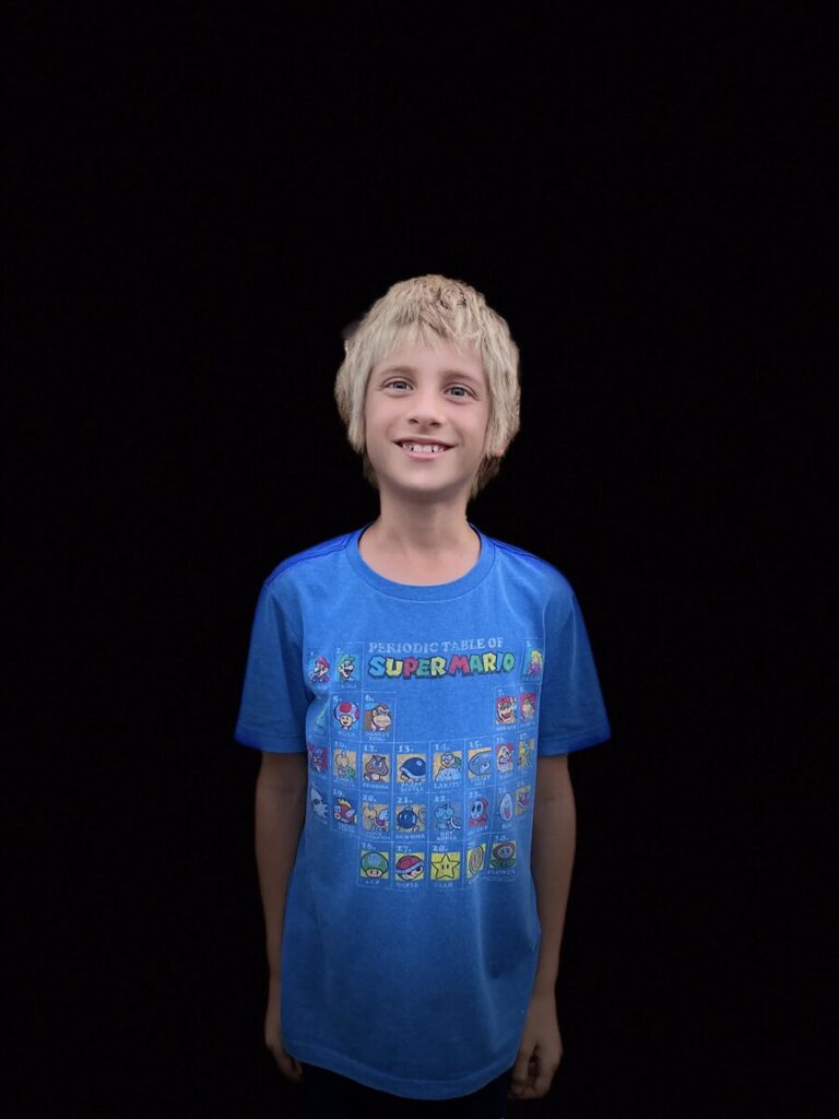 Isaiah in 2022, smiling in a blue Super Mario shirt